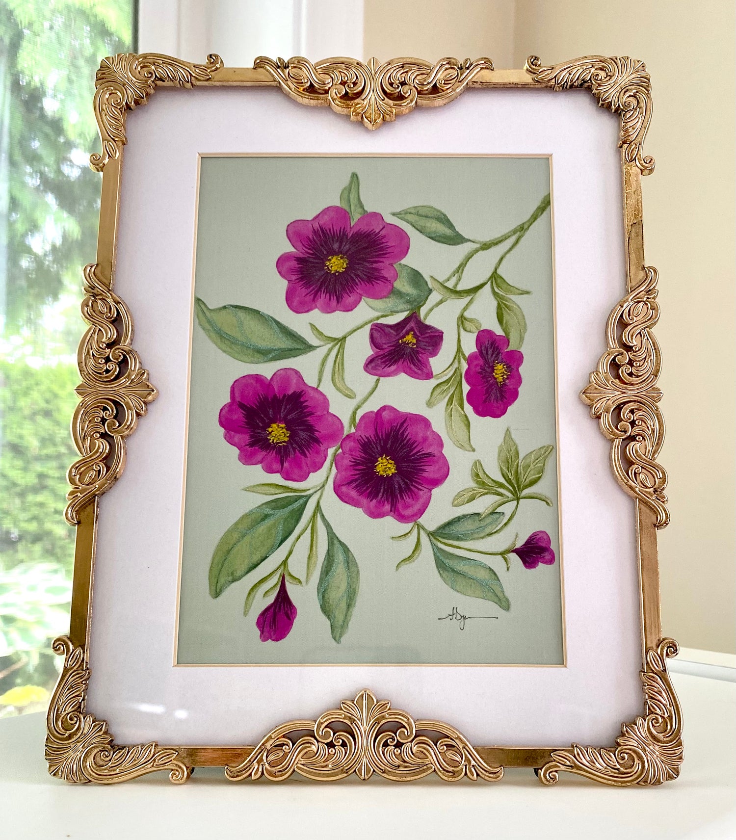 Framed artwork of purple flowers with green leaves on a light background
